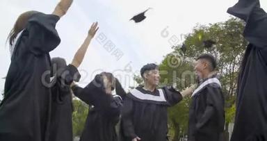 在大学校园里穿毕业礼服拿毕业证书的快乐学生